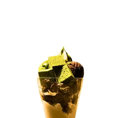 A tall glass filled with ice cream and chocolate